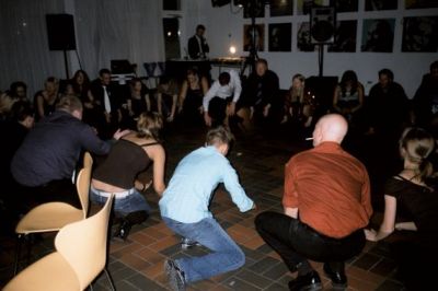 Deltagerne ligger på gulvet og klapper til en sang om en jysk lokalbane
