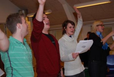 I salen er underviserne gået igang med at synge
